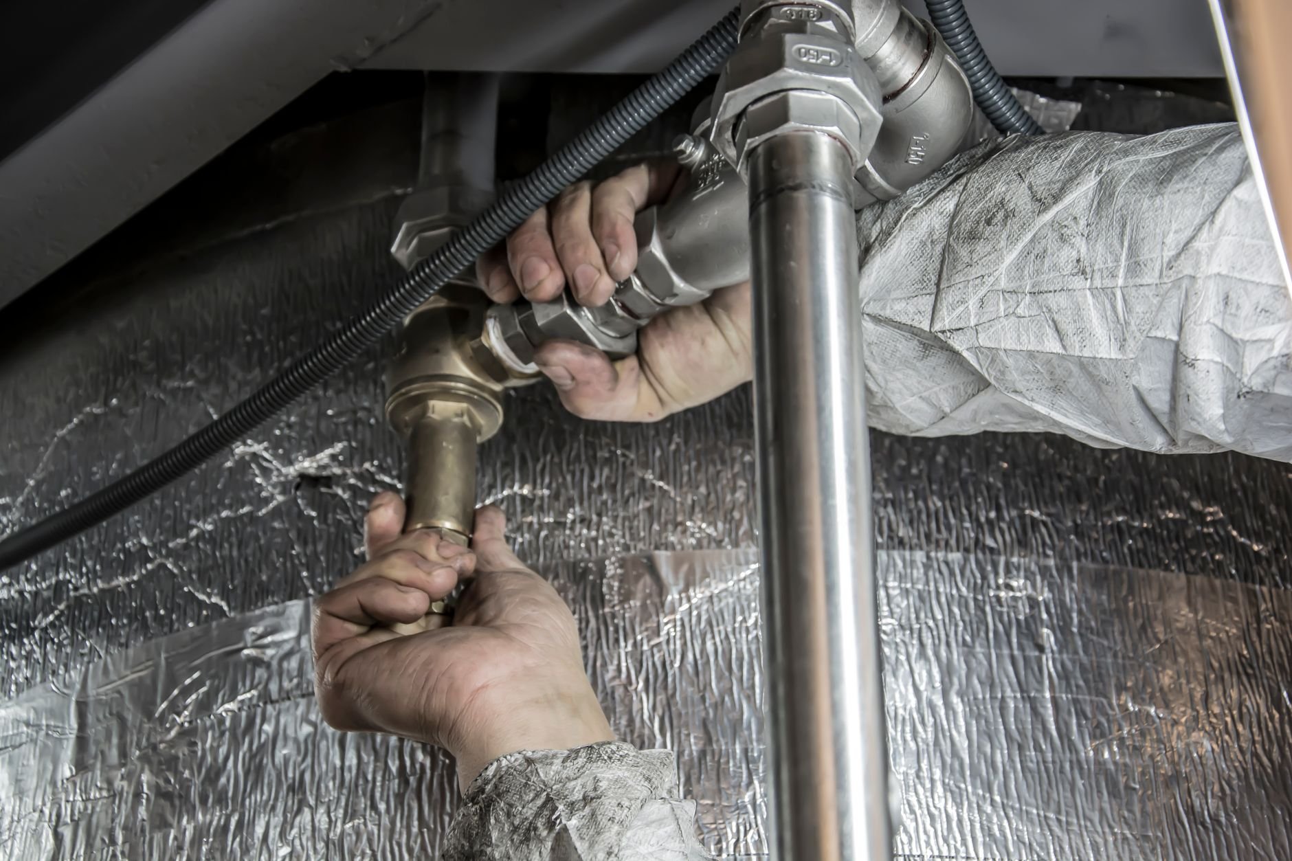 Plumber working on pipe installation with skill
